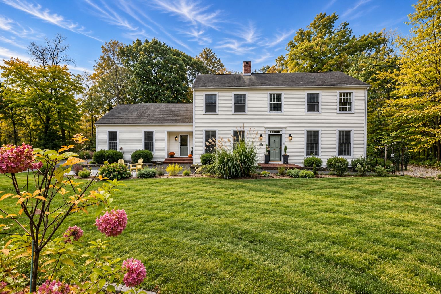 White Colonial at 51 Patterson Lane with a green lawn and hydrangeas in autumn