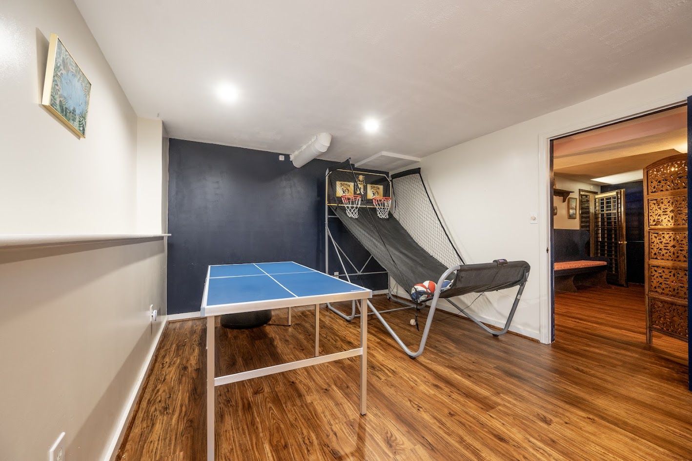 Finished lower level with ping pong table and arcade basketball